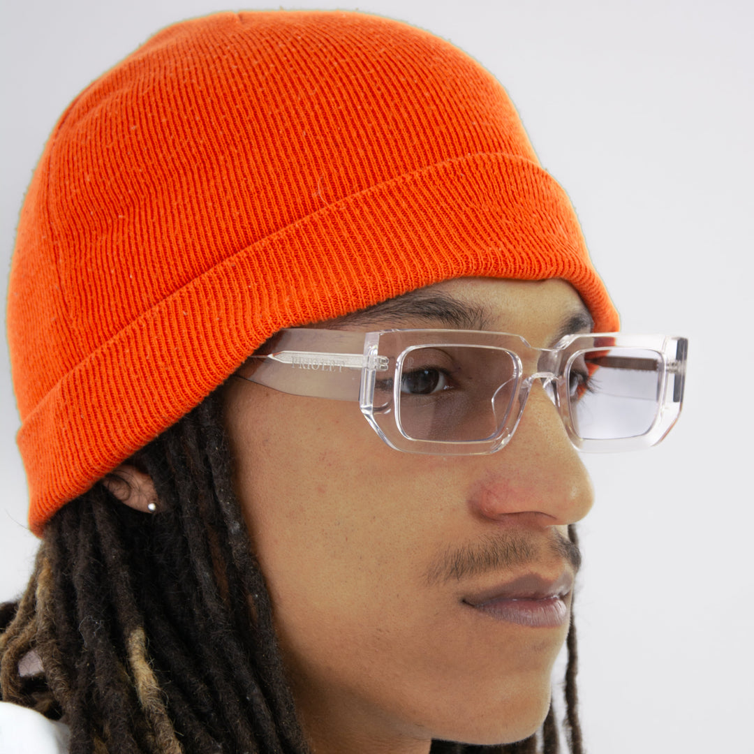 Galaxsos Midnight – Unisexbrille in Silber mit transparentem Rahmen, getragen von einem Model mit oranger Mütze in seitlicher Ansicht.