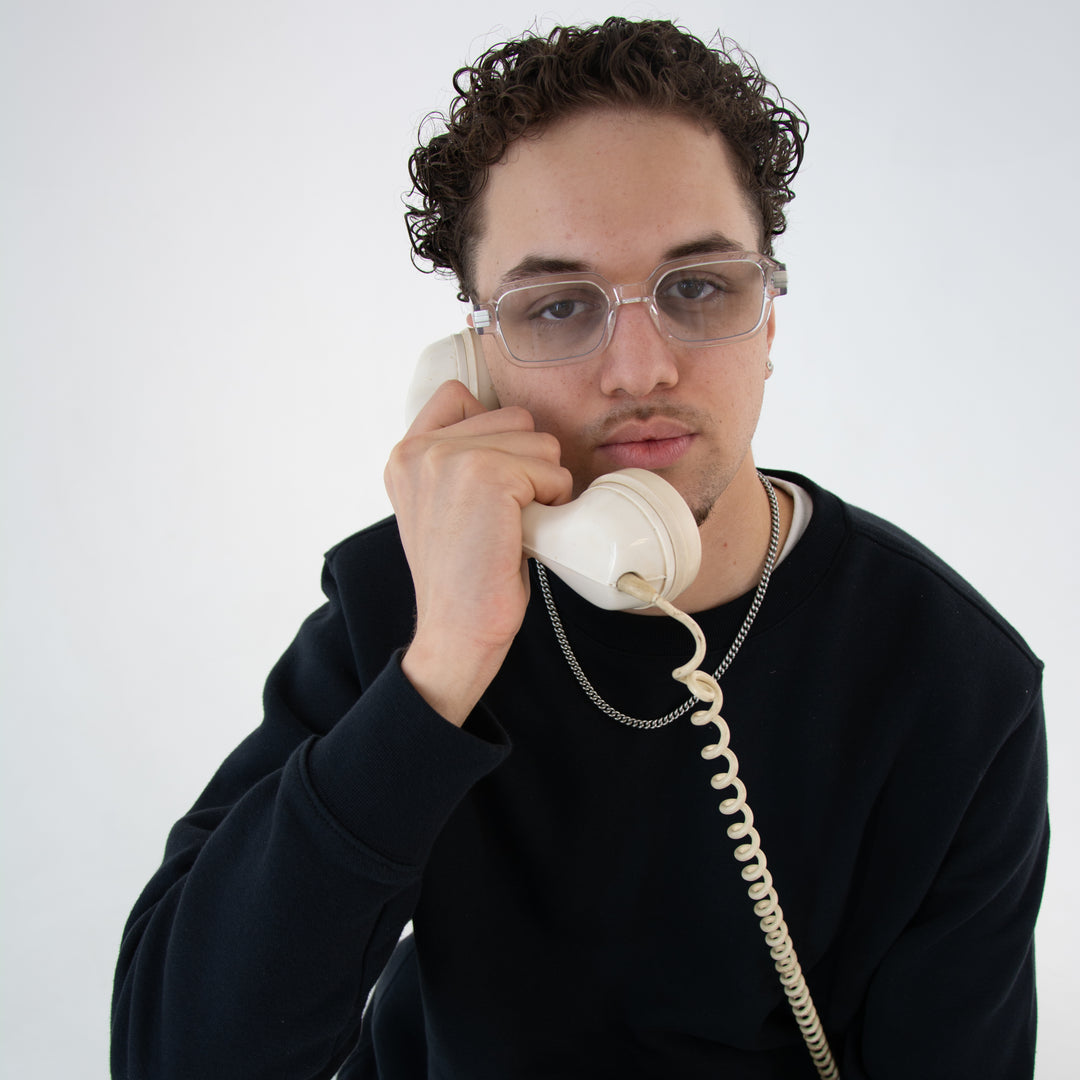 Model mit Luxora Midnight Unisex-Brille in Silber – klarer Acetatrahmen, Vintage-Telefon, moderner Streetstyle-Look